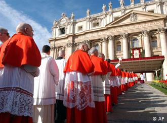 A row of cardinals wearing white robes, red capes and red hats walks up to St Peter's Cathederal