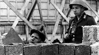 Vojnik nadzire zidara koji radi na Zidu