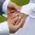 Жених надевает невесте на палец обручальное кольцо