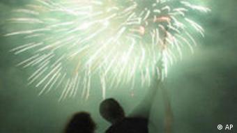 People watch as fireworks explode over Copacabana Beach, Rio de Janeiro, Brazil, Wednesday, Dec. 31, 2003. (AP Photo/Douglas Engle)
