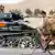 German tank passes a bicyclist in Afghanistan