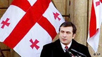 Mikhail Saakashvili stands under the Georgian flag
