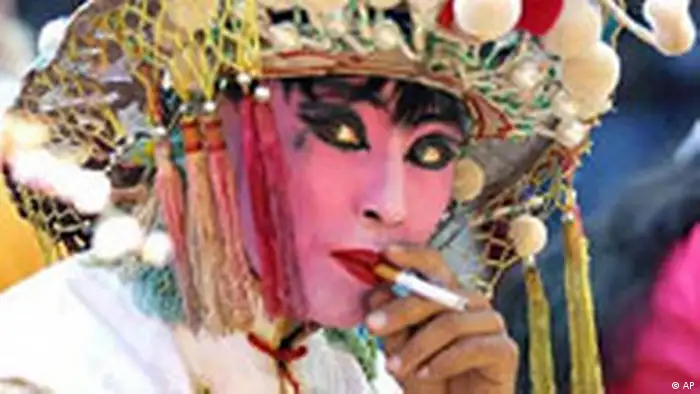 A performer takes a cigarette break between shows at a Lantern Festival celebration at a temple in Tianjin, east of Beijing, Tuesday, Feb. 26, 2002. The Lantern Festival, which falls on the 15th day of the Chinese Lunar New Year, marks the end of the traditional holiday period held to celebrate Spring Festival. China has the world's largest population of smokers, at more than 300 million. (AP Photo/str)