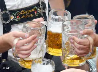 Besucher stoßen beim Münchener Oktoberfest mit Bier an. (AP Photo/Ferdinand Ostrop)