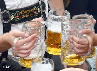 Besucher stoßen beim Münchener Oktoberfest mit Bier an. (AP Photo/Ferdinand Ostrop)