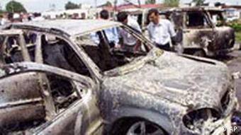 People look at burned out jeeps at Nazran, Ingushetia