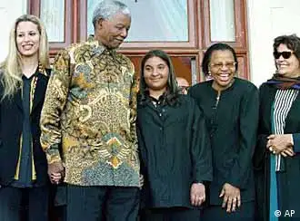 South African President Nelson Mandela, introduces the family of Libyan President Moammar Khadaffi to reporters at his residence in Cape Town, South Africa Sunday, June 6, 1999. Gadaffi's wife, Ssafia Farkash Albarassi, right, and two daughters, Aisha, 22, left, and Hanna,13, are in South Africa, at the invitation of South African first lady Graca Machel, second from right. (AP Photo/Obed Zilwa)