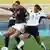 USA's Shannon Boxx, right, fights for the ball with Germany's team captain Birgit Prinz during a women's semifinal soccer match at the Pankritio stadium during the 2004 Olympic Games in Heraklion on the Greek island of Crete on Monday, Aug. 23, 2004. (AP Photo/ Yiorgos Papanikolaou)
