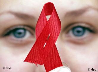 Woman holding up the AIDS symbol, a twisted red ribbon