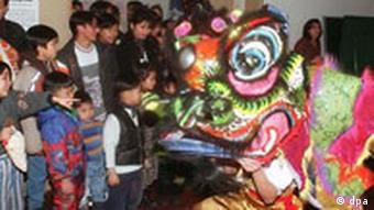 Vietnamesisches Neujahrsfest: Kinder und ihre Eltern bestaunen einen Drachen (Foto: dpa)