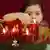 Ein Mädchen zündet die vierte Kerze eines Adventskranzes an (21.12.2004/dpa)