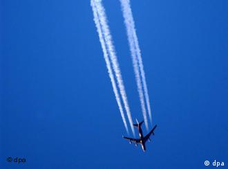 A plane leaves a white vapor trail on a blue sky
