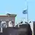 The Greek flag flies at half staff in front of the Parthenon