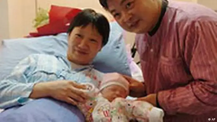Parents caress their newborn baby at Beijing Maternity Hospital in Beijing early Thursday, Jan. 6, 2005. The lucky newborn, weighing 3,660 grams and measuring 52 cm long, counted China's 1.3 billionth citizen. (AP Photo/Xinhua, Chen Shugen)