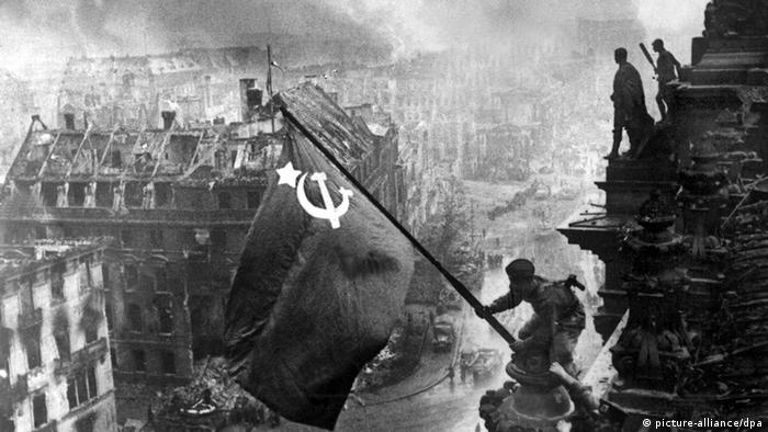 Schwarz-Weiß-Foto, zwei Sowjetsoldaten hissen Flagge auf Reichstag (picture-alliance/dpa)