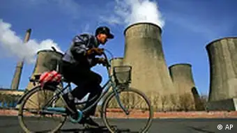 Radfahrer vor Kohlekraftwerk in China