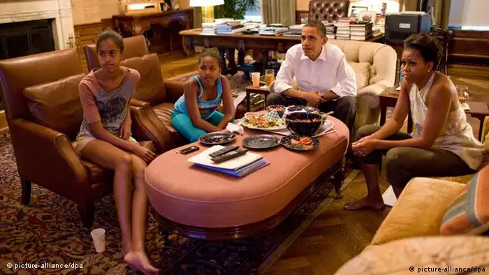Obama family on couches and chairs, watching TV (picture-alliance/dpa)