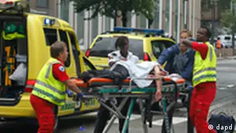 A victim is carried to a waiting ambulance in central Oslo, Friday July 22, 2011, following an explosion that tore open several buildings including the prime minister's office, shattering windows and covering the street with documents.(Foto:Berit Roald, Scanpix, Norway/AP/dapd) NORWAY OUT: