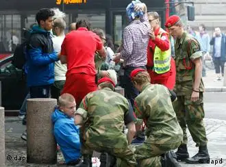 CORRECTS YEAR Wounded people are treated in the street in the centre of Oslo, Friday July 22, 2011, following an explosion that tore open several buildings including the prime minister's office, shattering windows and covering the street with documents and debris. (Foto:Scanpix, Berit Roald/AP/dapd) NORWAY OUT