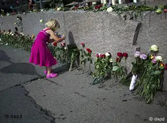 A young girl takes photos at a wall with flowers in memory of the victims of Friday's bomb attack and shooting rampage in Oslo, Norway, Tuesday, July 26, 2011. The defense lawyer for Anders Behring Breivik said Tuesday his client's case suggests he is insane, adding that someone has to take the job of defending him but that he will not take instructions from his client. Geir Lippestad told reporters that the suspect in the bombing on the capital and the brutal attack on a youth camp that killed at least 76 people is not aware of the death toll or of the public's response to the massacre that has rocked the country. (Foto:Emilio Morenatti/AP/dapd)