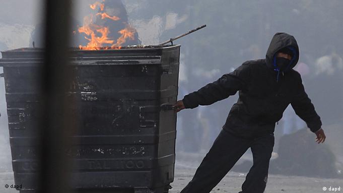 Vermummter Mann zieht brennenden Müllcontainer (Archivfoto: ap/dapd)