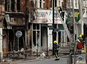 Fire fighters tend to a fire-damaged shop and flats above it after the rioting that took place the previous night near Clapham Junction railway station in Battersea, London, Tuesday, Aug. 9, 2011. British Prime Minister David Cameron recalled Parliament from its summer recess Tuesday and nearly tripled the number of police on the streets after three days of rioting in London blossomed into a full-blown political crisis. (Foto:Matt Dunham/AP/dapd)
