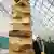 A wooden sculpture of stacked books attracts visitors' stares