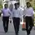 Трое молодых людей в белых рубашках на улице в Душанбе