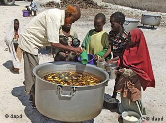 Somali children from southern Somalia, receive cooked food in Mogadishu