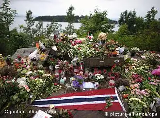 Blumen, Flaggen und Kerzen stehen im Gedenken an die Opfer am Freitag (19.08.2011) gegenüber der Fjordinsel Utoya in Norwegen. Vier Wochen nach der Bombenexplosion in Oslo und dem Massaker in einem Ferienlager auf der Fjordinsel Utöya gedenkt Norwegen der 77 Toten mit einer dreitägigen Trauerfeier. Foto: Hannibal dpa +++(c) dpa - Bildfunk+++