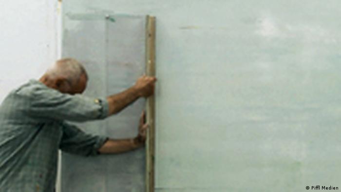 Der Maler Gerhard Richter verstreicht die Farbe mit einem breiten Rakel
