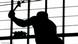 A black and white image of a worker with a hammer A black and white image of a worker with a hammer