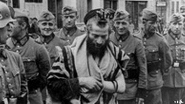 Photo en noir et blanc montrant le rabbin Moshe Hagerman dont se moquent des soldats de l'armée nazie, en 1940 en Ukraine