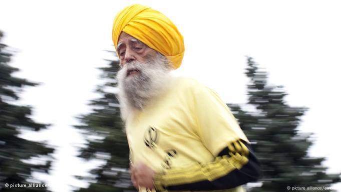 Fauja Singh, con barba y turbante, corriendo junto a unos pinos. Fauja Singh, con barba y turbante, corriendo junto a unos pinos.