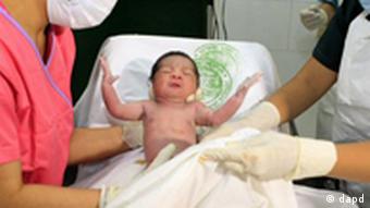 Midwives hold Danica Camacho, the Philippines' symbolic seven billionth baby