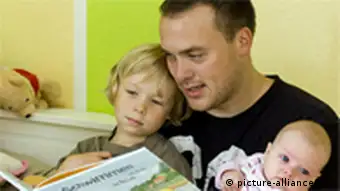 Andreas Lange mit seinem sohn Janne (4) und seiner drei Monate alten Tocher Fiona beim Vorlesen aus einem Bilderbuch , aufgenommen am 17.07.2008 in Frankfurt (Oder). Der 34-Jährige Vater hat drei Monate Elternzeit genommen. Foto: Patrick Pleul +++(c) dpa - Report+++