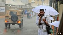 A pilgrim attending the hajj speaks on a mobile phone amidst heavy rains in Mecca, Saudi Arabia, Wednesday, Nov. 25, 2009. The heaviest rainstorms to hit Islam's annual hajj in years soaked pilgrims and flooded the road into Mecca, snarling traffic as millions of Muslims headed for the holy sites and added an extra hazard on top of intense concerns about the spread of swine flu. (AP Photo)