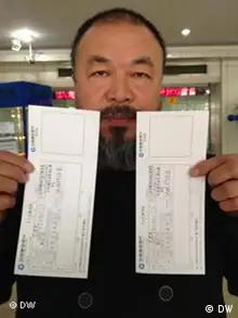 Ai Weiwei mit zwei Banküberweisungsscheine in der Hand. Verwendungszweck für die Überweisung lautet: Garantiezahlung. Bild von DW-Mitarbeiterin Su Yutong, 16.11.2011, Beijing