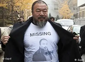 Chinese dissident artist Ai Weiwei opens his jacket to reveal a shirt bearing his portrait as he walks into the Beijing Local Taxation Bureau, China, Wednesday, Nov. 16, 2011. Ai went to the local tax bureau to fill in paperwork for a $1.3 million guarantee, and told reporters he feels like he was paying a ransom. (Foto:Andy Wong/AP/dapd)