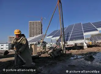 epa03019484 Chinese workers laboring at a construction site where large solar panels are installed in the Sino-Singapore Tianjin Eco-city in Tianjin Binhai New Area, China, 30 November 2011. A joint project by the Singapore and Chinese government, the Sino-Singapore Tianjin Eco-city is a 30 square kilometer development built with the latest green technologies and to serve as a model for future eco-cities in developing countries. With the capacity to accommodate 350,000 people, the eco-city features energy efficient buildings and use of renewable energy power sources such as solar, wind and geothermal energy. Countries are engaged in climate change talks in Durban aimed at cutting global carbon emissions of which China's position is key as the world's largest emitter of greenhouse gases. EPA/HOW HWEE YOUNG
