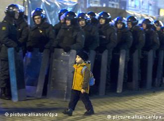 A boy walks in front of a row of riot police in Moscow