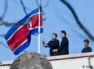 North Korean embassy staff members lower their national flag at half-mast to mourn the death of North Korean leader Kim Jong Il on the roof of the embassy in Beijing, China, Monday, Dec. 19, 2011. Kim Jong Il, North Korea's mercurial and enigmatic longtime leader, has died of heart failure. He was 69. (AP Photo/Andy Wong)