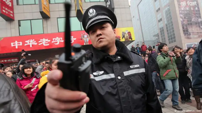 Files - A Chinese police officer disperses members of the public and media outside a McDonalds store after internet social networks called to join a 'Jasmine Revolution' protest in Wangfujing of central Beijing, China on 20 February 2011. Chinese police showed up in force to disperse a huge crowd of mostly onlookers gathered outside the fast food restaurant in Be