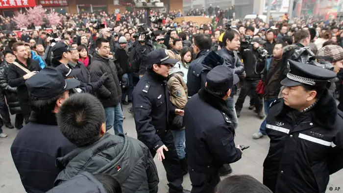 Chinese police officers urge people and journalist to leave an area in front of a McDonald's restaurant which was a planned protest site for Jasmine Revolution in Beijing, China, Sunday, Feb. 20, 2011. Jittery Chinese authorities staged a concerted show of force Sunday to squelch a mysterious online call for a Jasmine Revolution apparently modeled after pro-democracy demonstrations sweeping the Middle East. (AP Photo/Andy Wong)