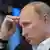 Владимир Путин в задумчивости потирает лоб
