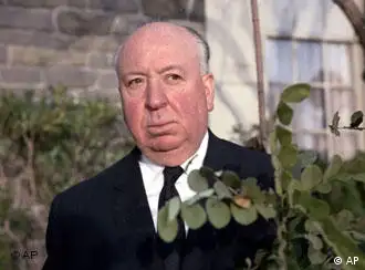 Der Filmregisseur, Produzent und Autor Alfred Hitchcock blickt hinter einem Busch hervor in Hollywood, USA, am 10. Feb. 1964.