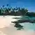 Ein Angler läuft über den Sandstrand des Paradise Beach an der Südküste der Insel Upolu in Samoa. Upolu ist neben Savaii die größte Insel des Inselstaats Samoa im südwestlichen Pazifik. Samoa umfasst den westlichen Teil der Samoainseln und ist auch als Westsamoa bekannt.(Undatierte Aufnahme)