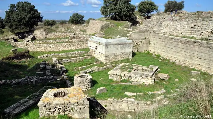 Archaeological site of Troy showing building remains in a grassy field.