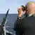 Ein Soldat der Bundesmarine blickt durch ein Fernglas auf das Meer (Foto: dpa)