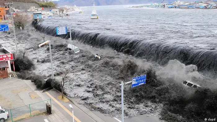 ARCHIV: Eine Flutwelle infolge des Tsunami bricht in Miyako, Japan, von der Flussmuendung des Heigawa ueber den Hafendamm hinweg (Foto vom 11.03.11). Bildpaket zum Fukushima-Jahresrueckblick Im Jahr des Super-GAU. (zu dapd-Text)..JAPAN OUT, NO SALES, MANDATORY CREDIT Foto: Mainichi Shimbun/Tomohiko Kano/AP